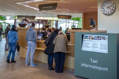 Mensen bij het taxi-informatiepunt Mensen bij het taxi-informatiepunt